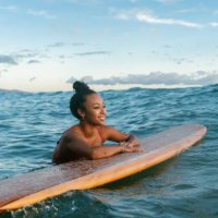young woman resting on her surfboard waiting for a wave - travel stock pictures, royalty-free photos & images