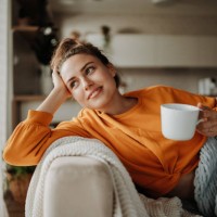 young woman resting on sofa with cup of tea. - home decoration stock pictures, royalty-free photos & images