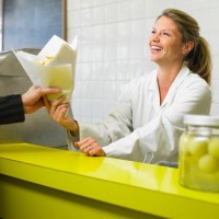 young woman serving customer in fish and chip shop, smiling - junk food stock pictures, royalty-free photos & images
