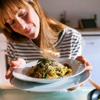 young woman serving vegan pasta dish - food stock pictures, royalty-free photos & images