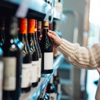 young woman shopping wine in supermarket - junk food stock pictures, royalty-free photos & images