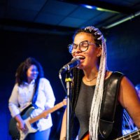 young woman singing and playing bass on a show - concert stock pictures, royalty-free photos & images