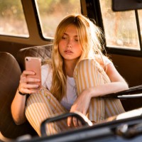 young woman sitting in a van using cell phone - fashion stock pictures, royalty-free photos & images