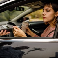 young woman sitting in her car and paying for takeaway coffee with credit card to a service person - junk food stock pictures, royalty-free photos & images