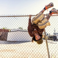 young woman smiling and hanging upside down on fence - fashion photos et images de collection