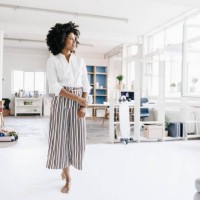 young woman standing in her apartment, looking confident - fashion stock-fotos und bilder