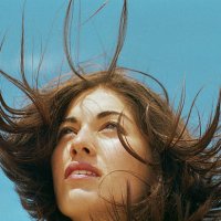 young woman standing outdoors, hair blowing, close-up - hairstyle stock pictures, royalty-free photos & images