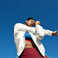 young woman stretching arm against clear blue sky on sunny day - fashion stock pictures, royalty-free photos & images
