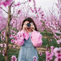 young woman taking photos of blossoming fruit trees with a retro camera in spring - fashion stock pictures, royalty-free photos & images