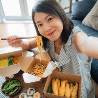 young woman taking selfie while eating takeaway food - junk food stock pictures, royalty-free photos & images