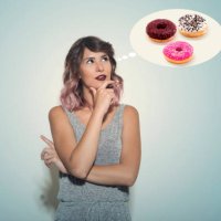 young woman thinking about an assortment of donuts - junk food stock pictures, royalty-free photos & images