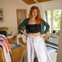 young woman trying on a shirt she picked out in her bedroom at home - fashion stock pictures, royalty-free photos & images