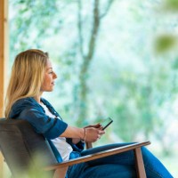 young woman using digital tablet while sitting on armchair at front yard - garden decoration photos et images de collection