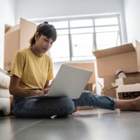 young woman using laptop at new house - home decoration stock pictures, royalty-free photos & images