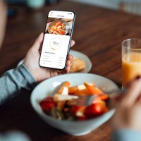 young woman using mobile app to track nutrition and count calories with smartphone - food stock pictures, royalty-free photos & images
