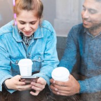 young woman using smartphone in a coffee shop while her boyfriend watching her - junk food stock pictures, royalty-free photos & images