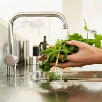 young woman washing lettuce at kitchen sink, close-up of hands - food stockfoto's en -beelden