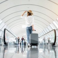 young woman wearing casual clothes and walking in the airport hall - travel photos et images de collection