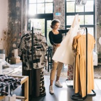 young woman with a keen eye for fashion, browsing through a curated collection of dresses - fashion stock pictures, royalty-free photos & images