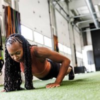 young woman with braided hair doing push-ups at gym - hairstyle stockfoto's en -beelden