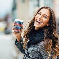 young woman with coffee cup smiling outdoors - coffee stockfoto's en -beelden