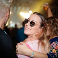 young woman with friends on live event, looking at camera over shoulder - concert stock pictures, royalty-free photos & images