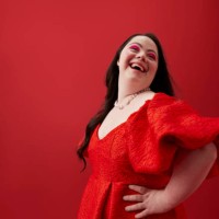 young woman with hand on hip against red background - fashion stock pictures, royalty-free photos & images