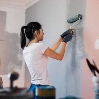 young woman with hearing aid painting walls - home decoration stock pictures, royalty-free photos & images