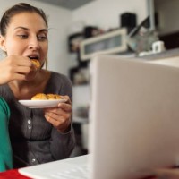 young woman working and eating at home office - junk food stock pictures, royalty-free photos & images