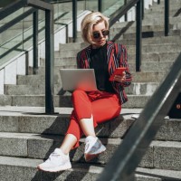 young woman working on laptop sitting on stairs. - fashion stock pictures, royalty-free photos & images