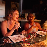 young women laughing together during a new year's eve dinner party - food stock pictures, royalty-free photos & images