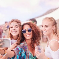 young women posing for selfie at music festival - concert stockfoto's en -beelden