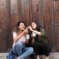 young women sharing cookies with coffee - junk food stock pictures, royalty-free photos & images