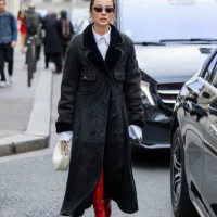 Yoyo Cao wears creme white bag, shearling black coat, white button shirt, red boots outside Valentino during the Womenswear Fall/Winter 2024/2025 as...