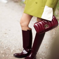 Yoyo Cao wears green mini shorts, white top, green beanie or a hat, green coat, burgundy boots, burgundy bag outside Gucci show during the Milan...