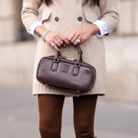 Yoyo Cao wears silver rings, shiny dark brown Miu Miu leather bag, outside Miu Miu, during the Paris Fashion Week Spring/Summer 2025 on October 1,...