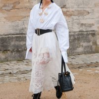 Yuwei Zhangzou wears white shirt, cream lace maxi skirt, black belt, black Dior bag, black boots, outside Dior, during the Womenswear Fall/Winter...