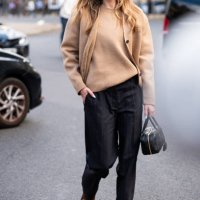 Zita d'Hauteville wears a beige Miu Miu sweater with matching cardigan, black trousers and black Miu Miu bag, outside Miu Miu, during the Womenswear...