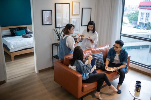 4 vrienden verzamelen thuis voor een snelle maaltijd - junk food stockfoto's en -beelden