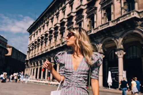 a beautiful businesswoman with sunglasses looking away while standing in the street - fashion stock pictures, royalty-free photos & images