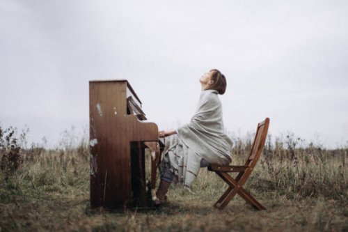 a beautiful woman is playing the piano with pleasure in a field in autumn - concert stock pictures, royalty-free photos & images