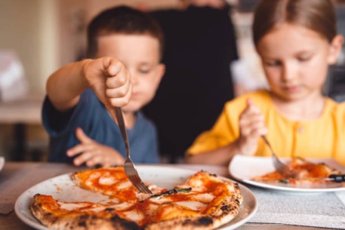 a boy and a girl share a pizza in a cafe. - junk food stock pictures, royalty-free photos & images