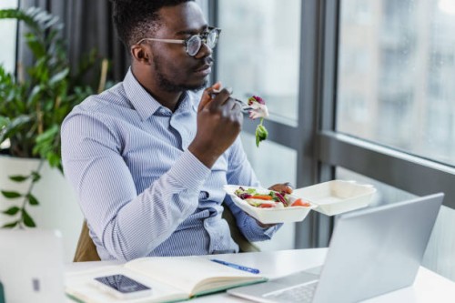 a businessman is having a lunch break in the office - junk food stock pictures, royalty-free photos & images