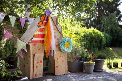 a child's colourful homemade playhouse in a back yard made from recycled cardboard boxes - garden decoration stock pictures, royalty-free photos & images