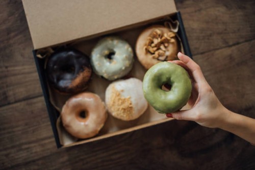 a choice of various delicious crafted donuts from a takeaway box - junk food stock pictures, royalty-free photos & images