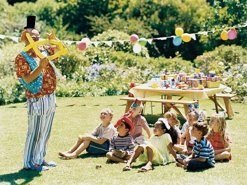 a clown amuses a medium group of children at a birthday party - garden decoration stock pictures, royalty-free photos & images