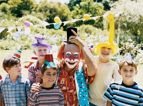 a clown posing with boys at a birthday party in a garden - garden decoration stock pictures, royalty-free photos & images