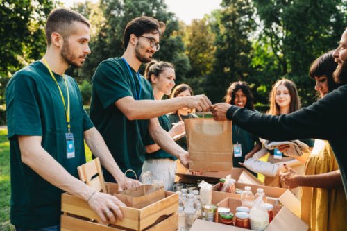 a couple is taking a bag of food at the food and clothes bank - food stock pictures, royalty-free photos & images