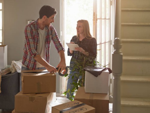 a couple moving home, the woman is using an tablet computer - home decoration stock pictures, royalty-free photos & images