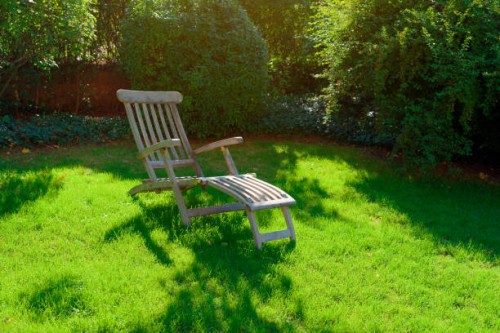 a deck chair stands in a garden on a green meadow in summer - garden decoration photos et images de collection